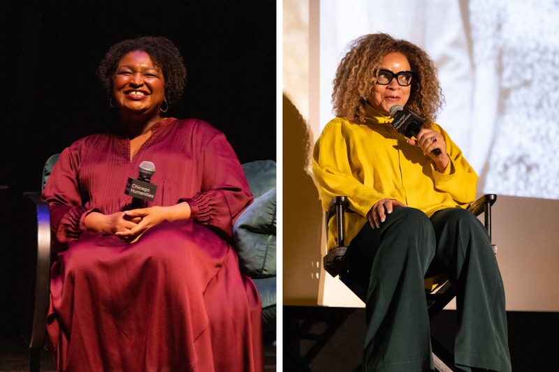 Two side-by-side images of women sitting on stages. Stacey Abrams, left, wears a satin deep maroon caftan and a big smile, holding a microphone. Ruth E. Carter, right, knowingly speaks into a mic. She has large blonde curly hair, big black square glasses, and wears chic oversized yellow jacket and green pants.