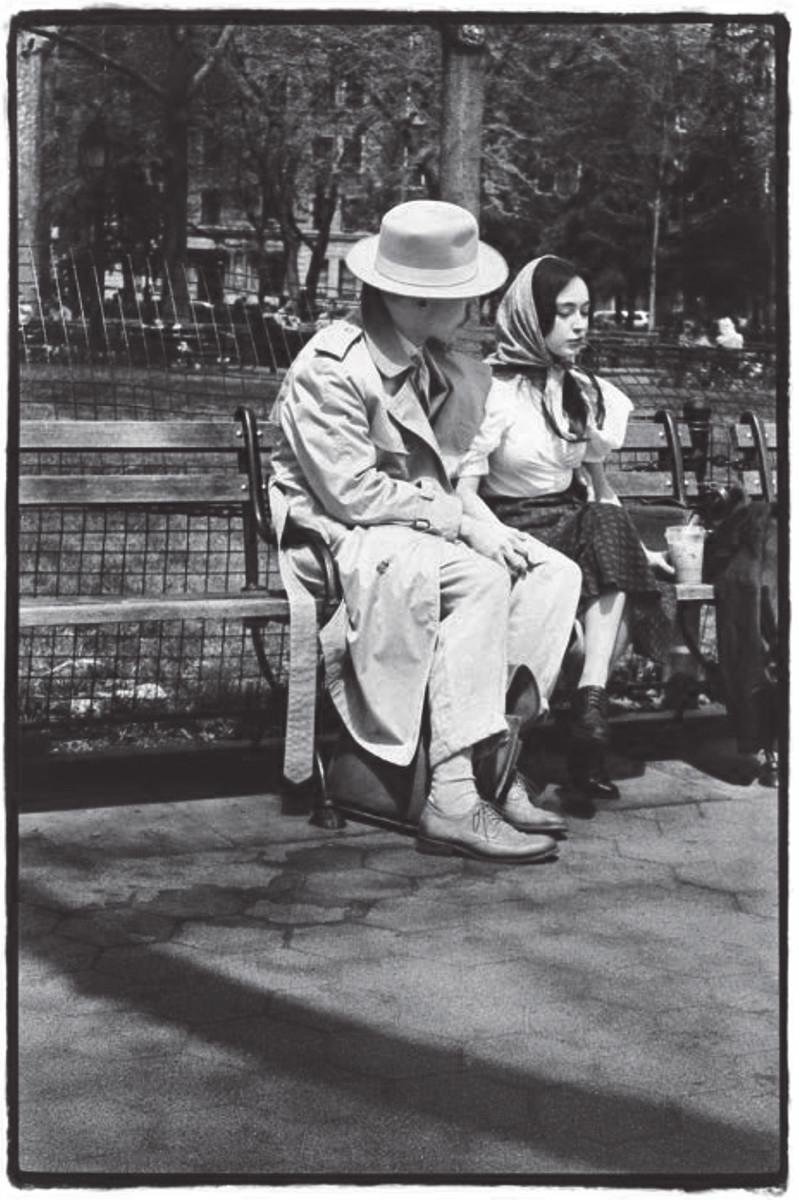 alt text: A black and white photo of a young couple on a park bench, dressed out of a bygone era - except for the woman’s iced coffee.