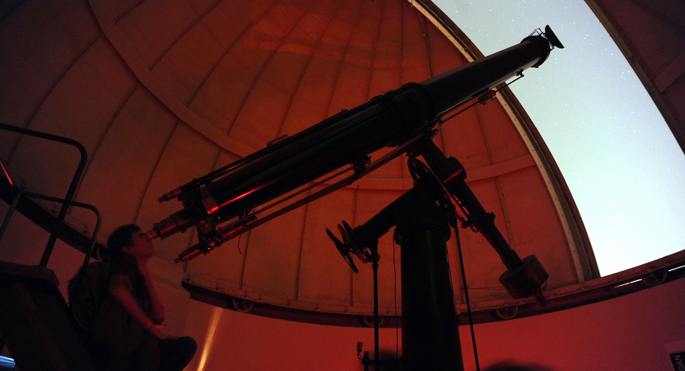 Imagen de una mujer mirando por los telescopios del observatorio de Cerro Calán