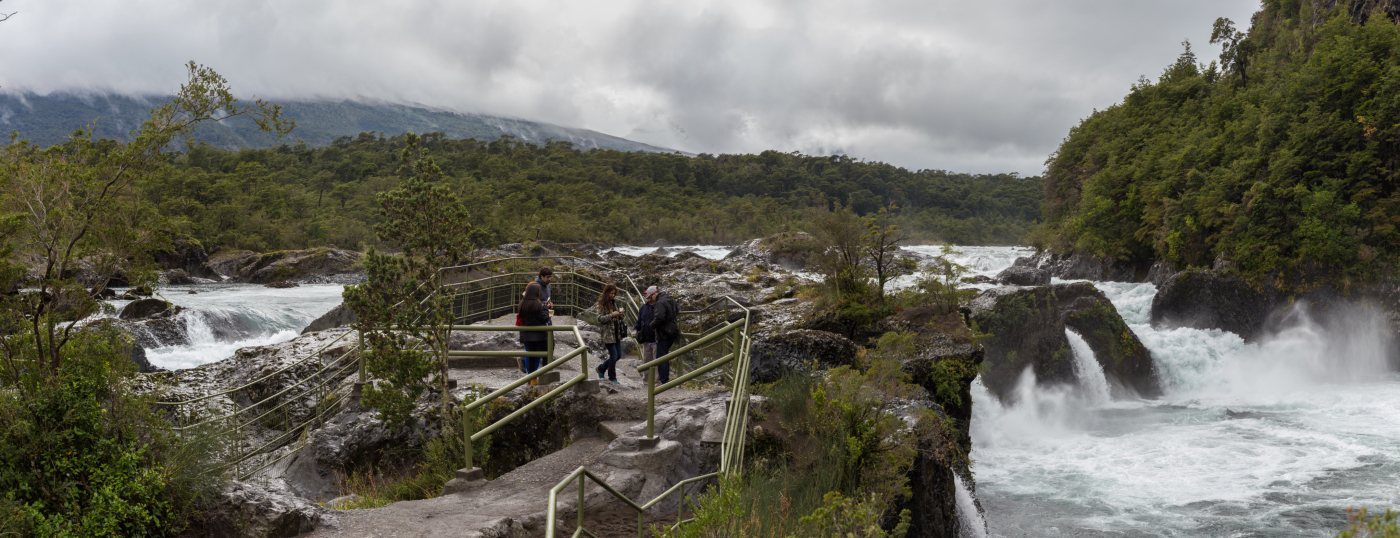 Imagen de unos turistas recorriendo los senderos guiados en medio de cascadas de agua en el Parque Nacional Vicente Perez Rosales