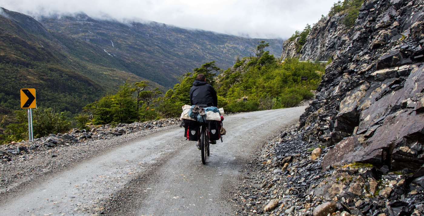 Imagen de un hombre recorriendo la Carretera Austral en bicicleta, donde se ve el camio en buen estado