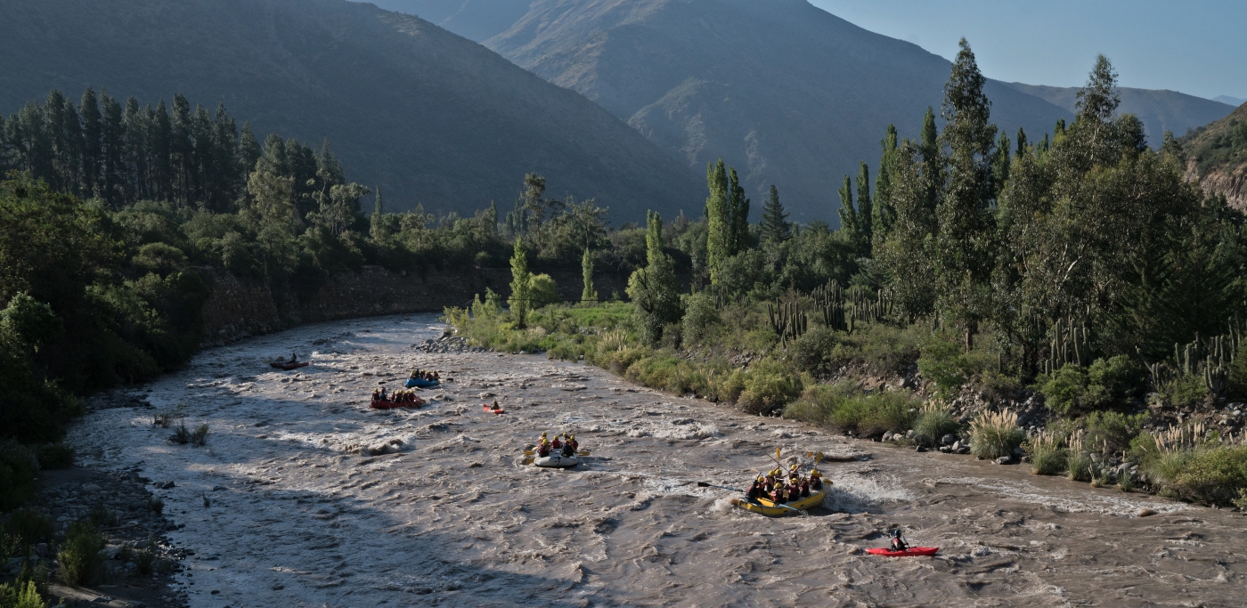 Imagen de un grupo d epersonas realizando rafting en el río del Cajón del Maipo en un día de otoño