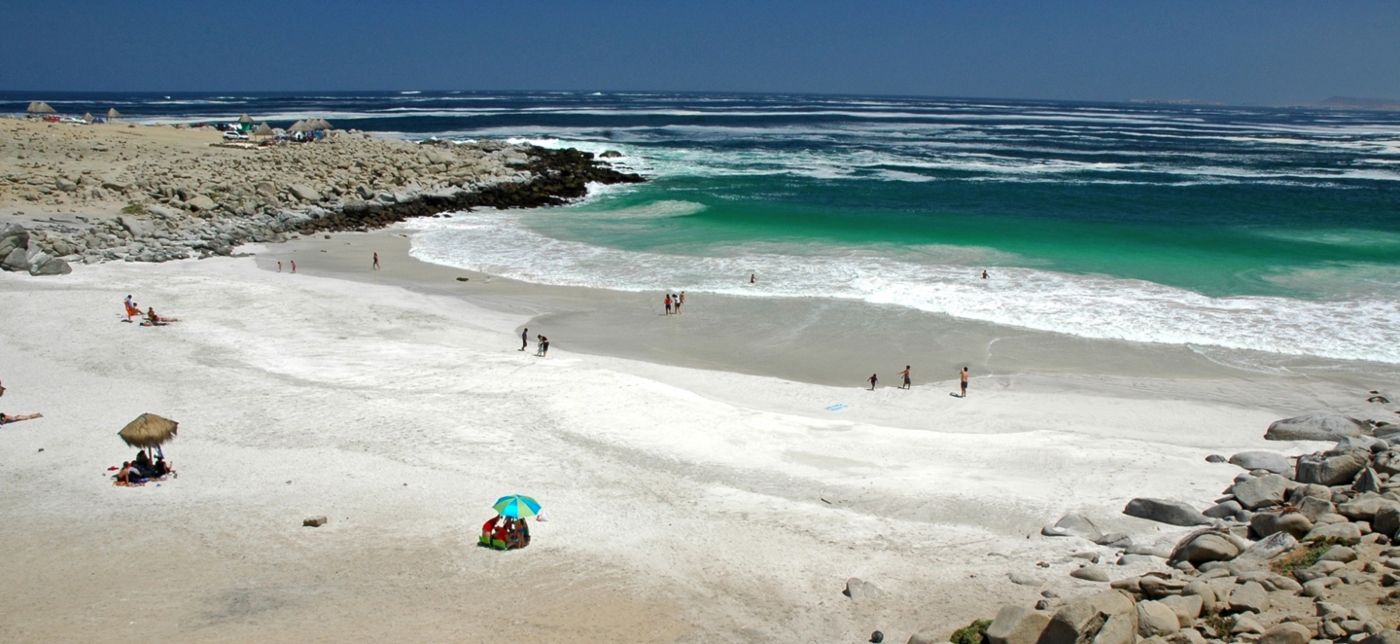 Imagen panorámica de Playa La Virgen donde se luce sus aguas limpias y arenas blancas