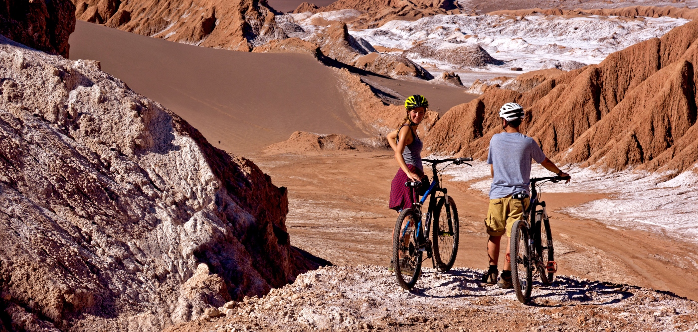 Imagen de una pareja de turistas recorriendo San Pedro de Atacama en bicicleta