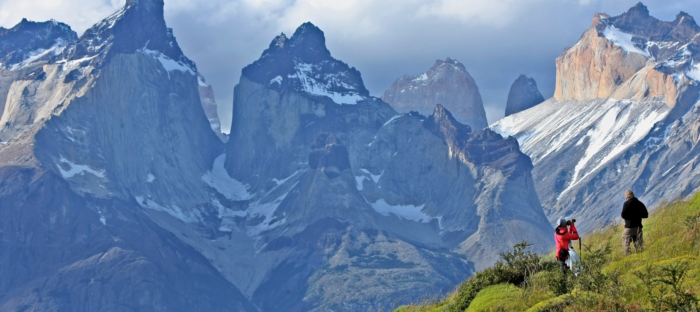 Imagen de los cuernos de las Torres del Paine donde destacan dos turistas fotografiando el paisaje