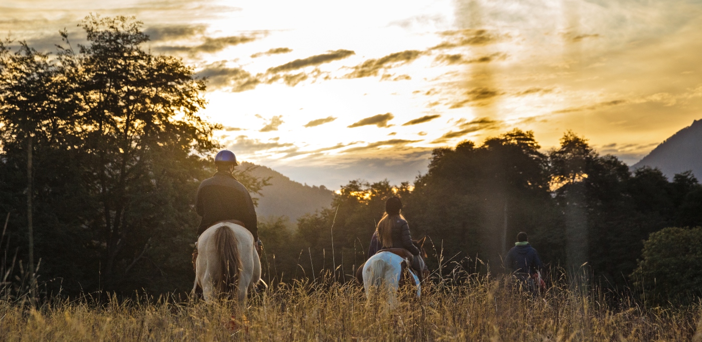 Imagen de una pareja cabalgando por la reserva natural Huilo Huilo