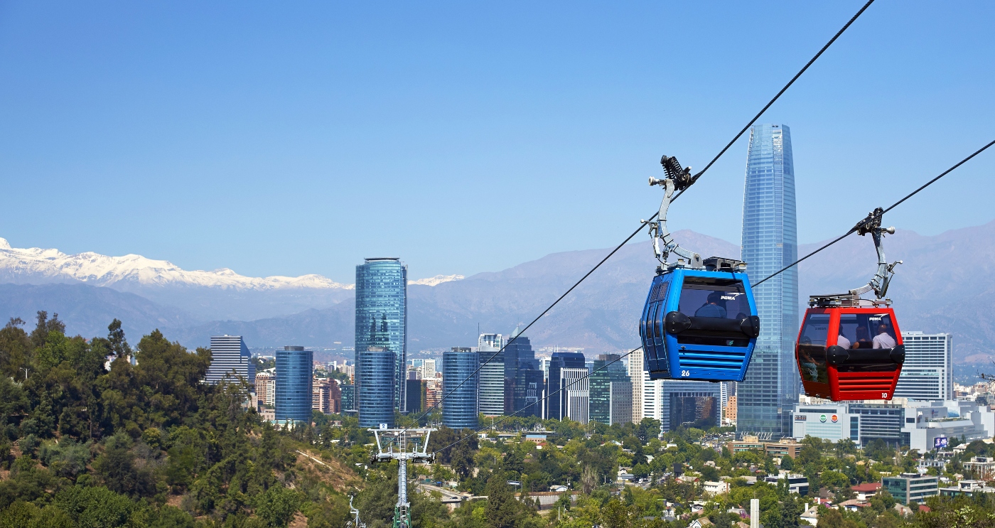 imagen del teleferico de Santiago con dos cápsulas de colores recorriendo la vía