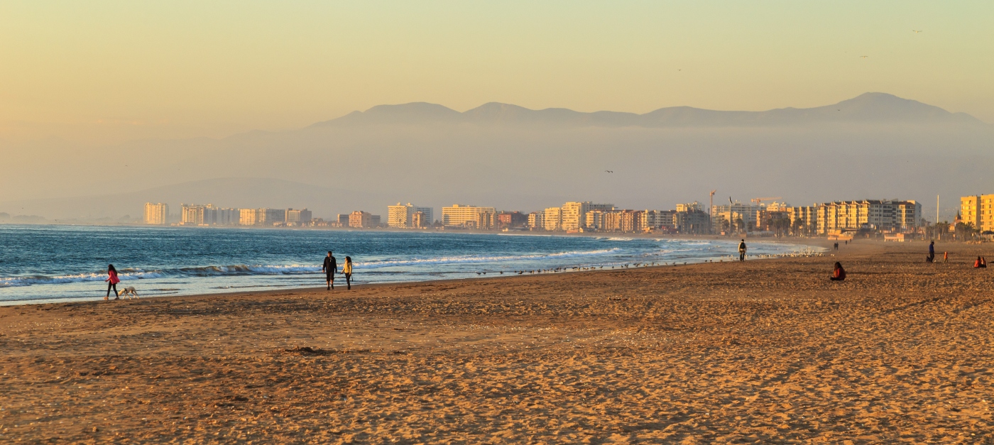 imagen panorámica de una pareja caminando por la orilla del mar en La Serena