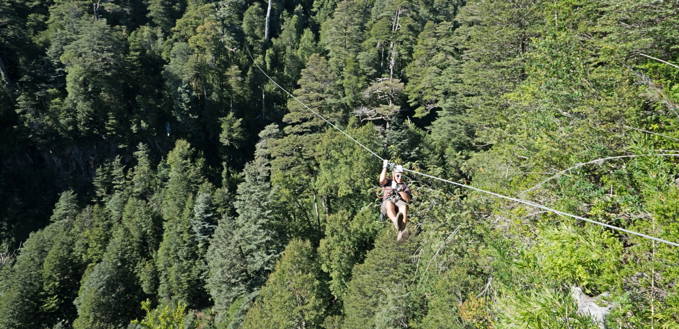 Imagen de un turista practicando canopy en puerto fuy