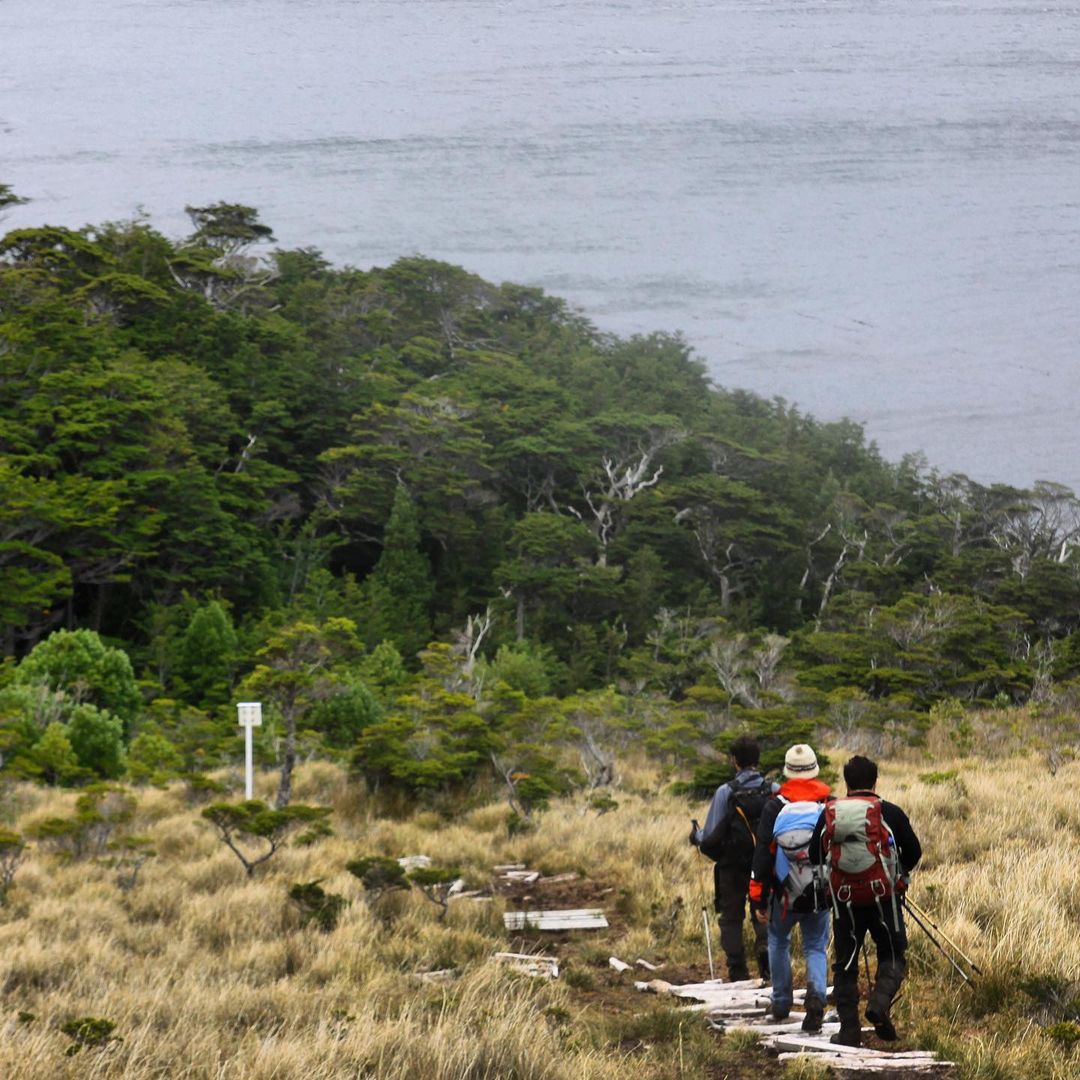 Three people walking along the heritage route of Cape Froward