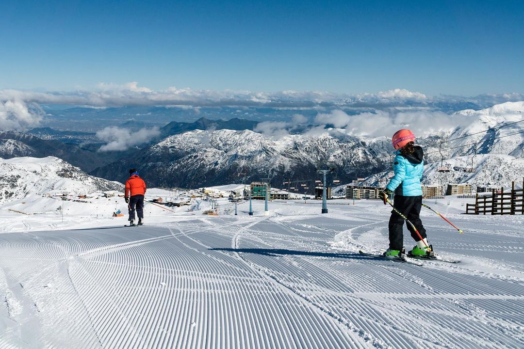 Skifahren von der Spitze des Berges mit Blick auf die verschneite Bergkette