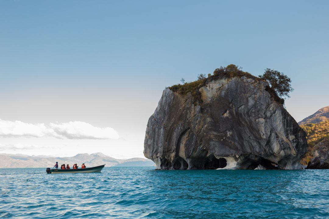 Tourists contemplating the Marble Chapels in Aysén from a boat.