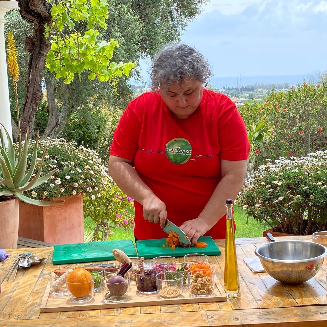 Chefköchin im Freien kochend mit Lebensmitteln aus dem Garten