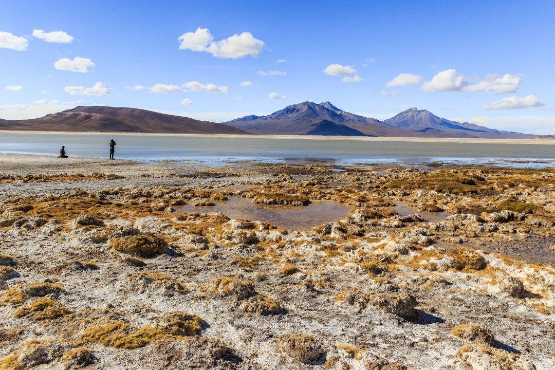 Two people in the immensity of the Surire Salt Flat in the North of Chile