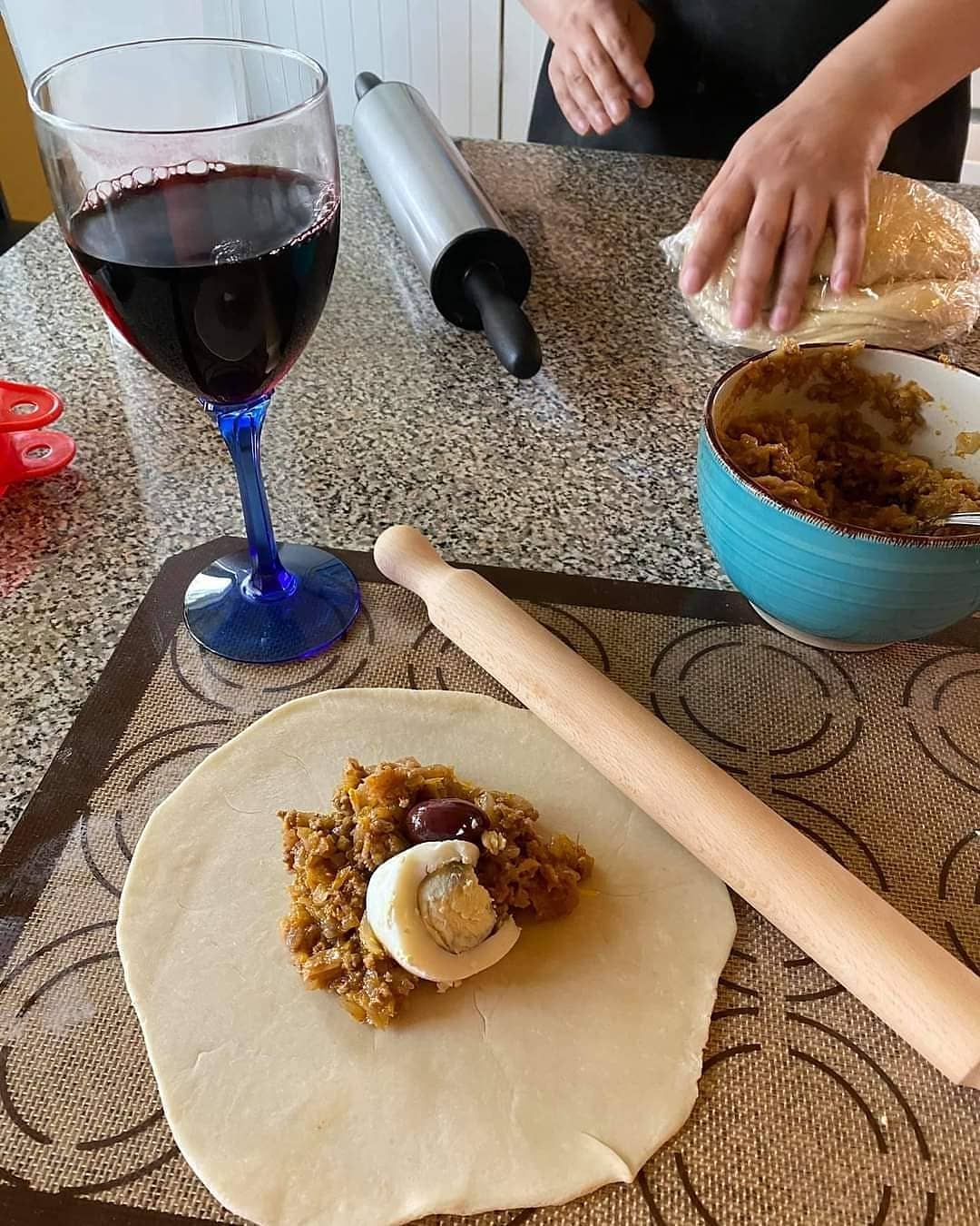 Empanada dough with pino filling and a glass of red wine 