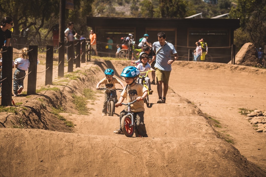 Kids riding their bikes over dirt jumps