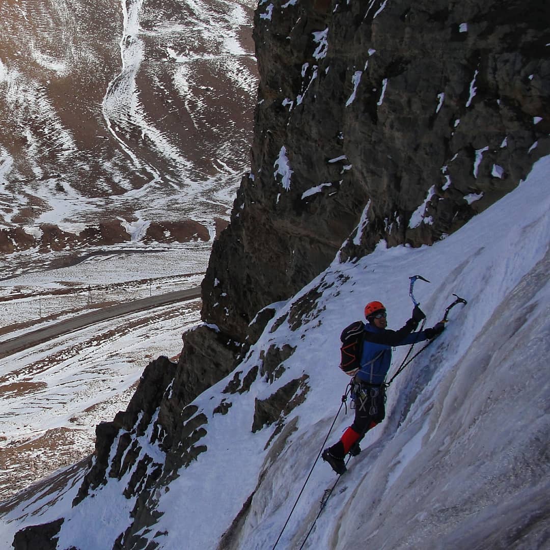 Mann beim Klettern an einer Eiswand