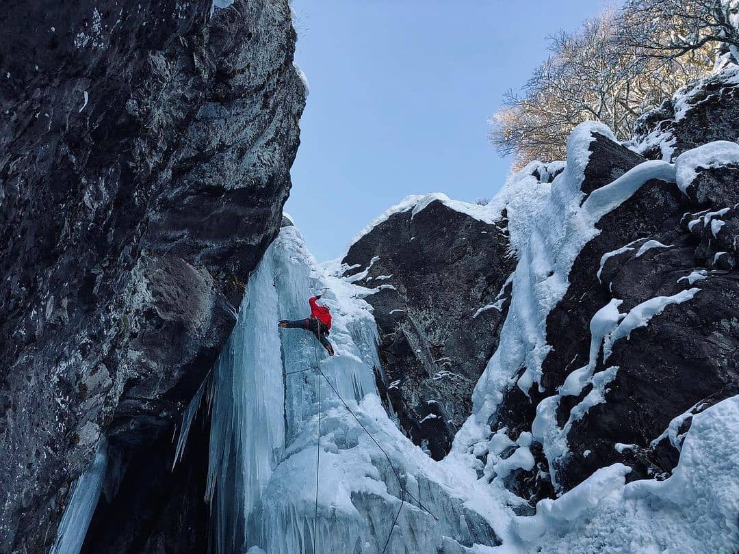 Mann klettert Wasserfall aus Eis in Portezuelo Ibañez