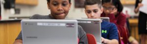 students looking at their laptop screen seating at their individual desks