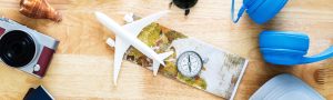 folded map with plastic airplane and compass on wooden table