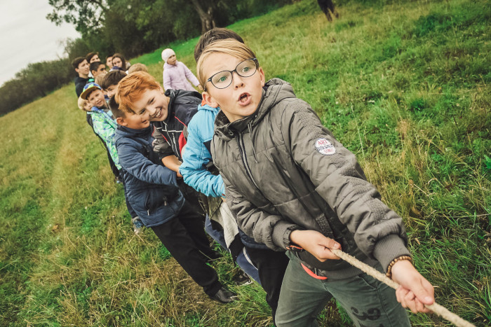 Group of kids pulling on a rope outside