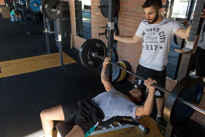 man spotting another guy on benchpress