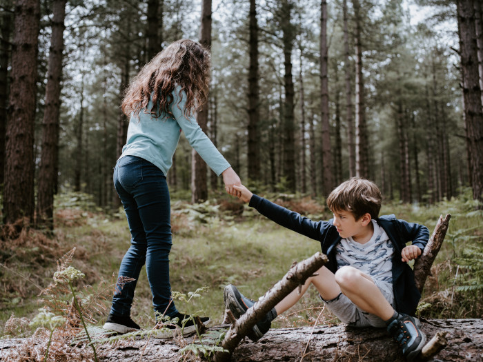 little girl helping out a boy to get back up