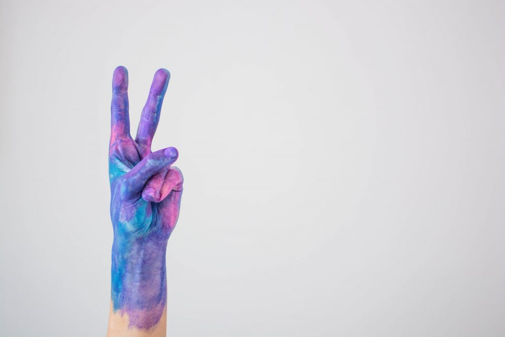 peace sign covered in purple and blue paint