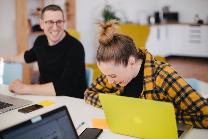 woman laughing in front of computer