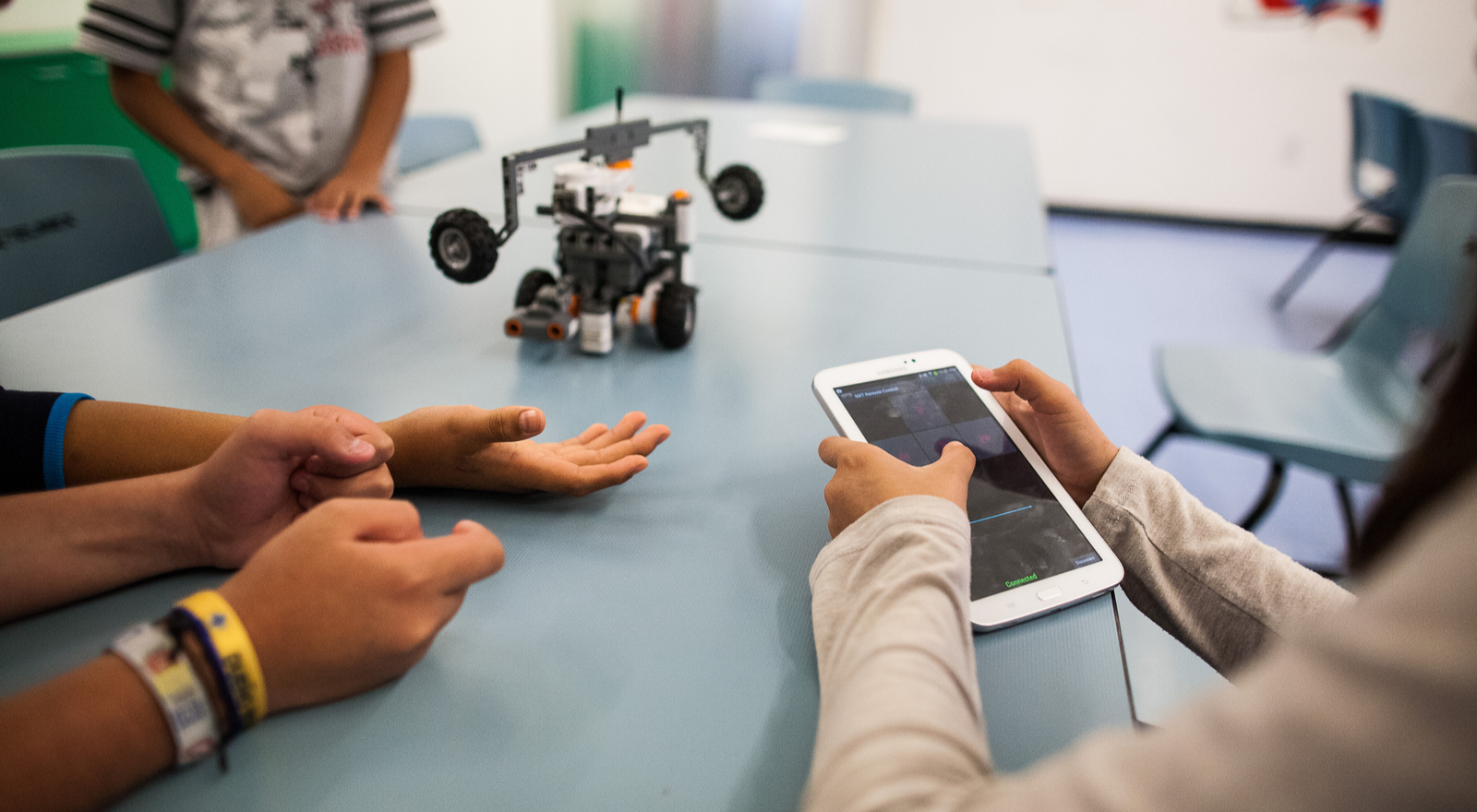 Students programming robot with tablet