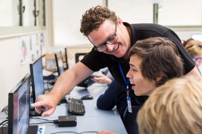 Teacher and student looking at screen