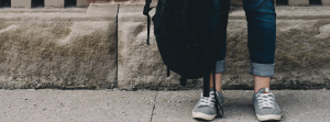 19- Person holding backpack near brick wall