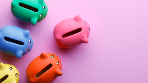 Multi colored piggy banks on a pink background