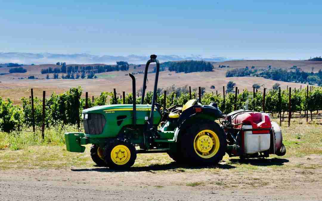 green and red tractor on brown field during daytime