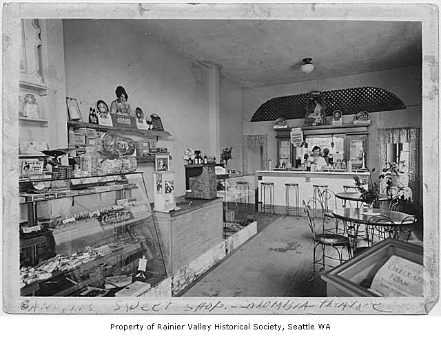 Carroll Eaton behind the counter of Carroll's Sweet Shop (in the lobby of Columbia City Theater), circa 1935