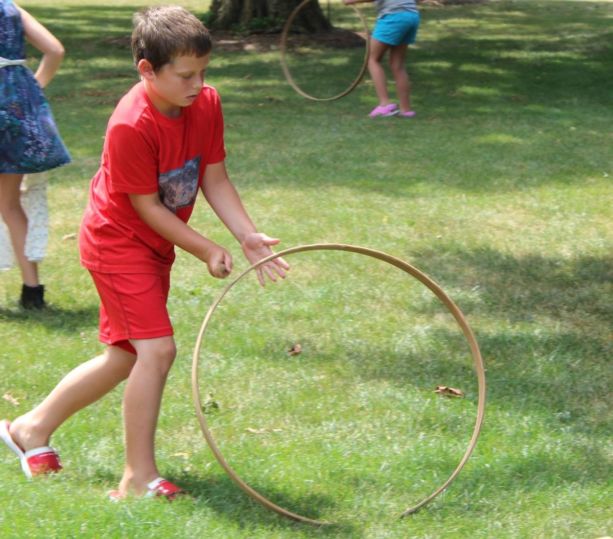Sandy Lu teaches students the game of "hoop and stick"