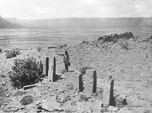 A Zuni man worshipping in front of the Old Zuni stone idols