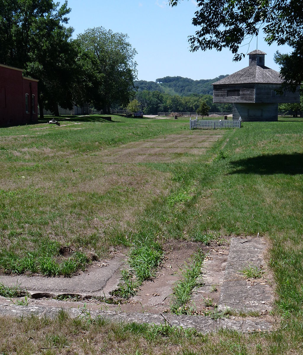 The foundations of the first fort with a reconstructed blockhouse in the background. The foundations are located just north of the Villa Louis house.