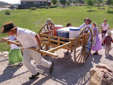 People taking part in a trek in portion of the site, trying to reenact how Mormon Pioneers traveled over 1000 miles west