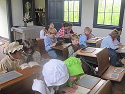 Children on a field trip at the schoolhouse