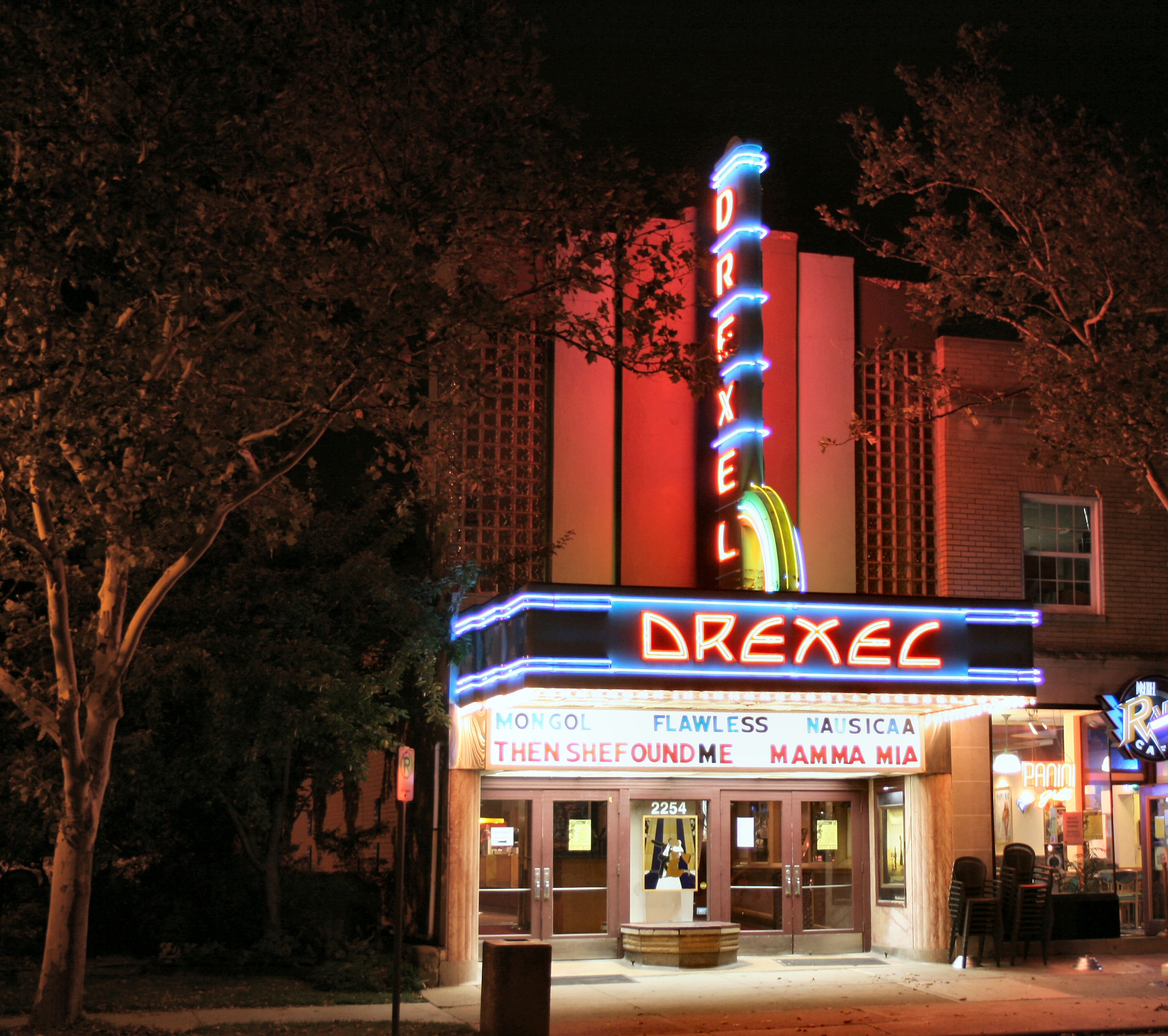 A view of the Drexel Theater's brightly-lit entrance.