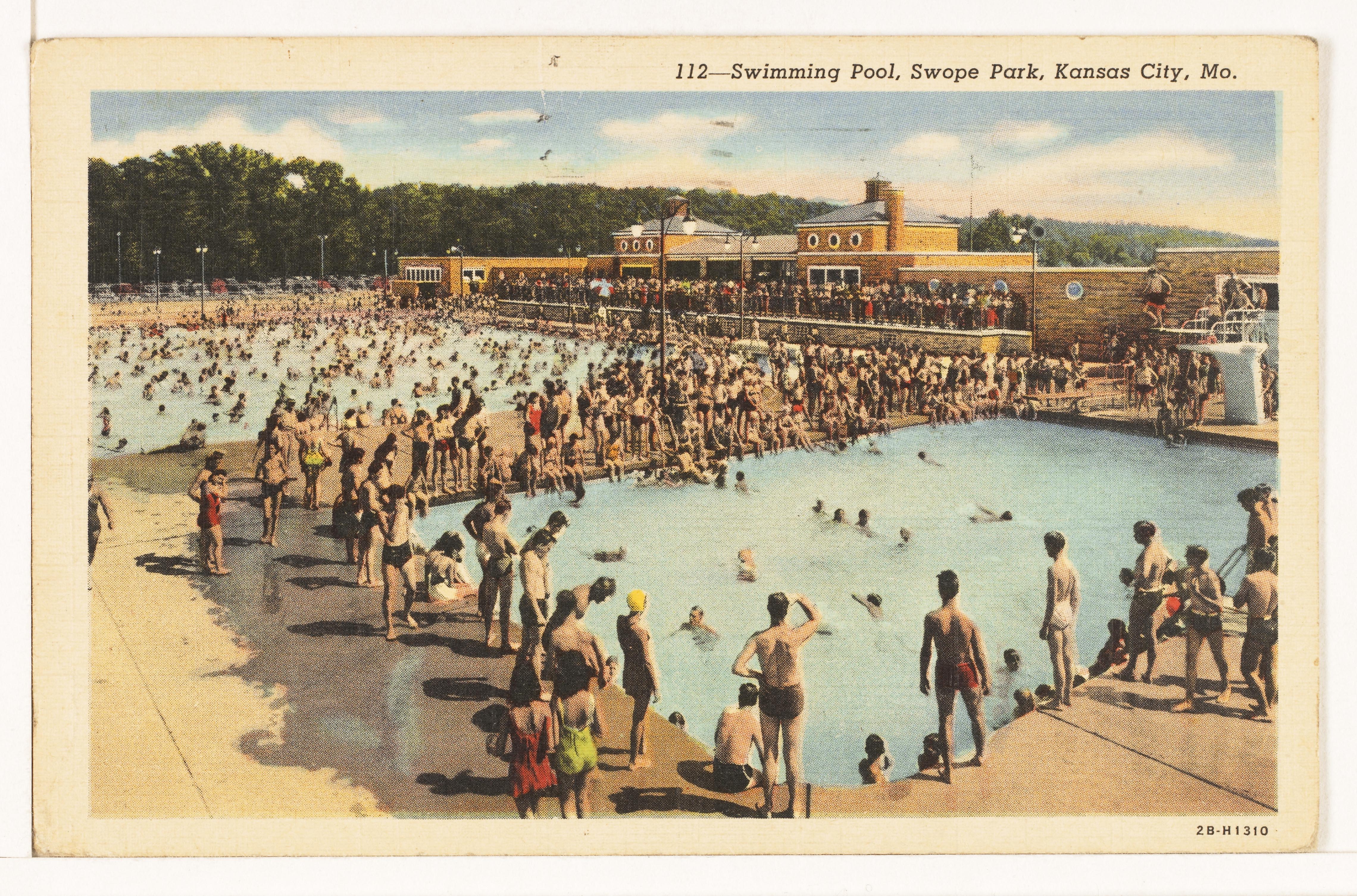 A printed color image showing a view of a crowded pool complex. Numerous people are in the water, with additional crowds on the edge. In the background, a building is visible as part of the complex.