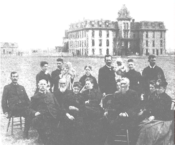 Jonathan Kennedy and his large family in front of the school soon after it opened. Jonathan is possibly the older gentleman seated front row, second from left.