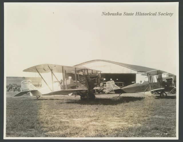 Planes sit at the airfield for the Lincoln Airplane and Flying School. The advertisement on the plane's tail reads, "Link Up with Lincoln." 