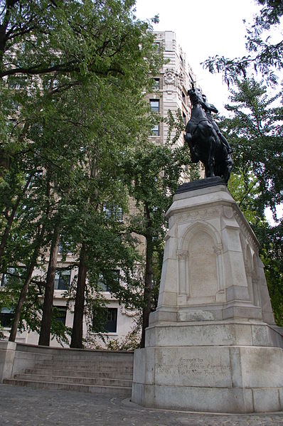 The statue is situated above eye level, forcing the viewer to look up at her as she rides into battle