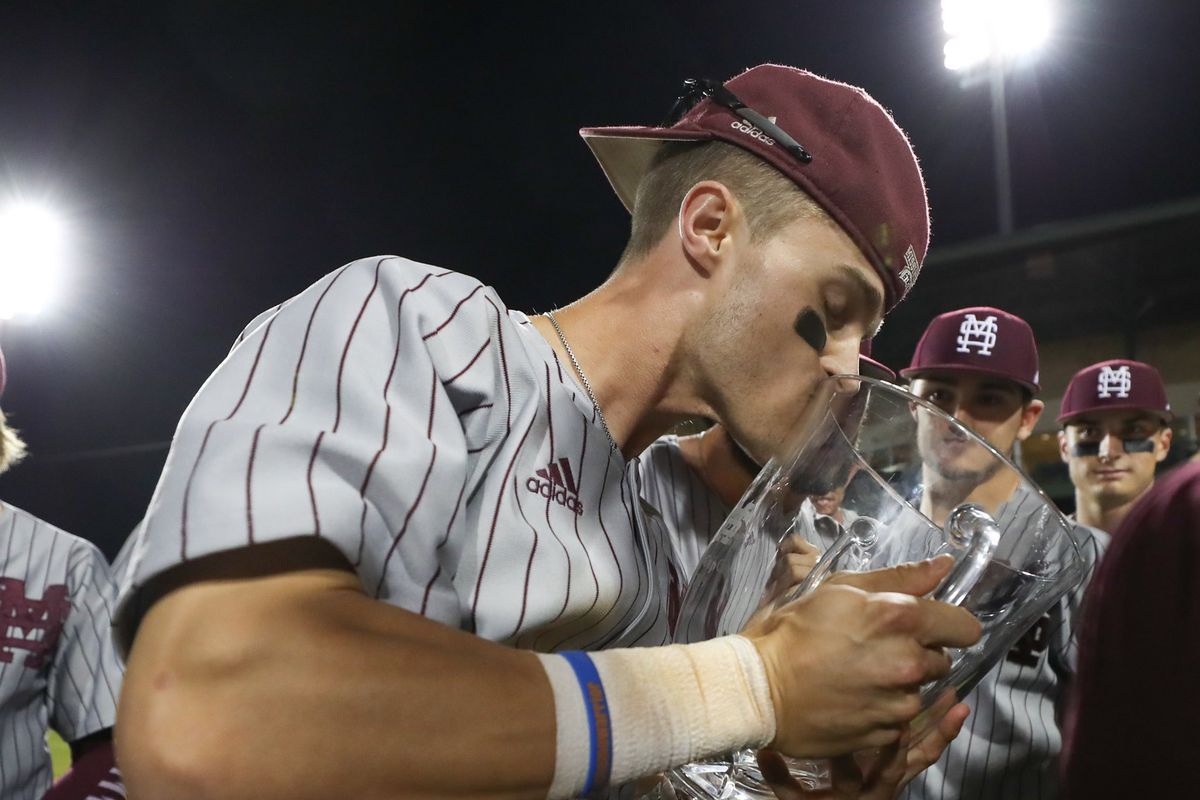 Mississippi State player kisses and holds the Governor's Cup, the trophy that both teams play for this series. 