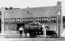 J.A. Skinner and one other in front of building soon after it was completed