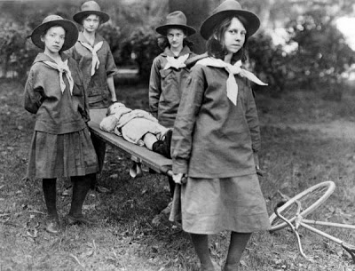 Mildred Nix Huie as a Girl Guide troop. Huie is standing third from left. They are carrying Johnny Mercer on the stretcher. 