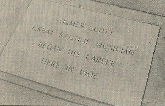 James Scott marker in sidewalk in front of building at this location.