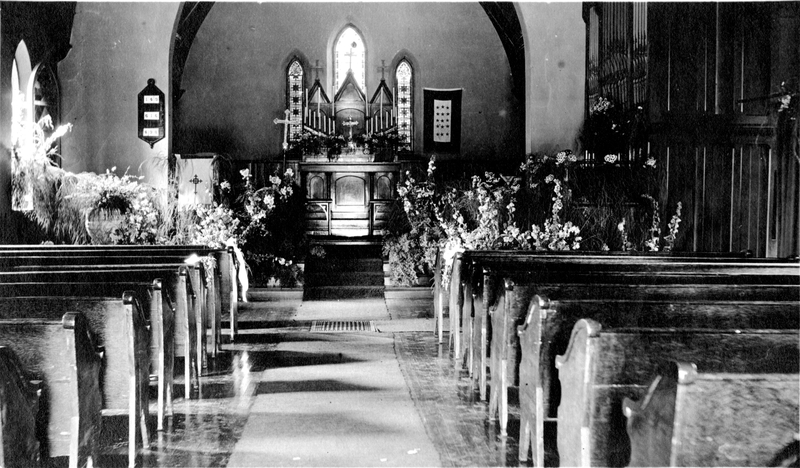 A church aisle decorated with flowers and fabric for a wedding